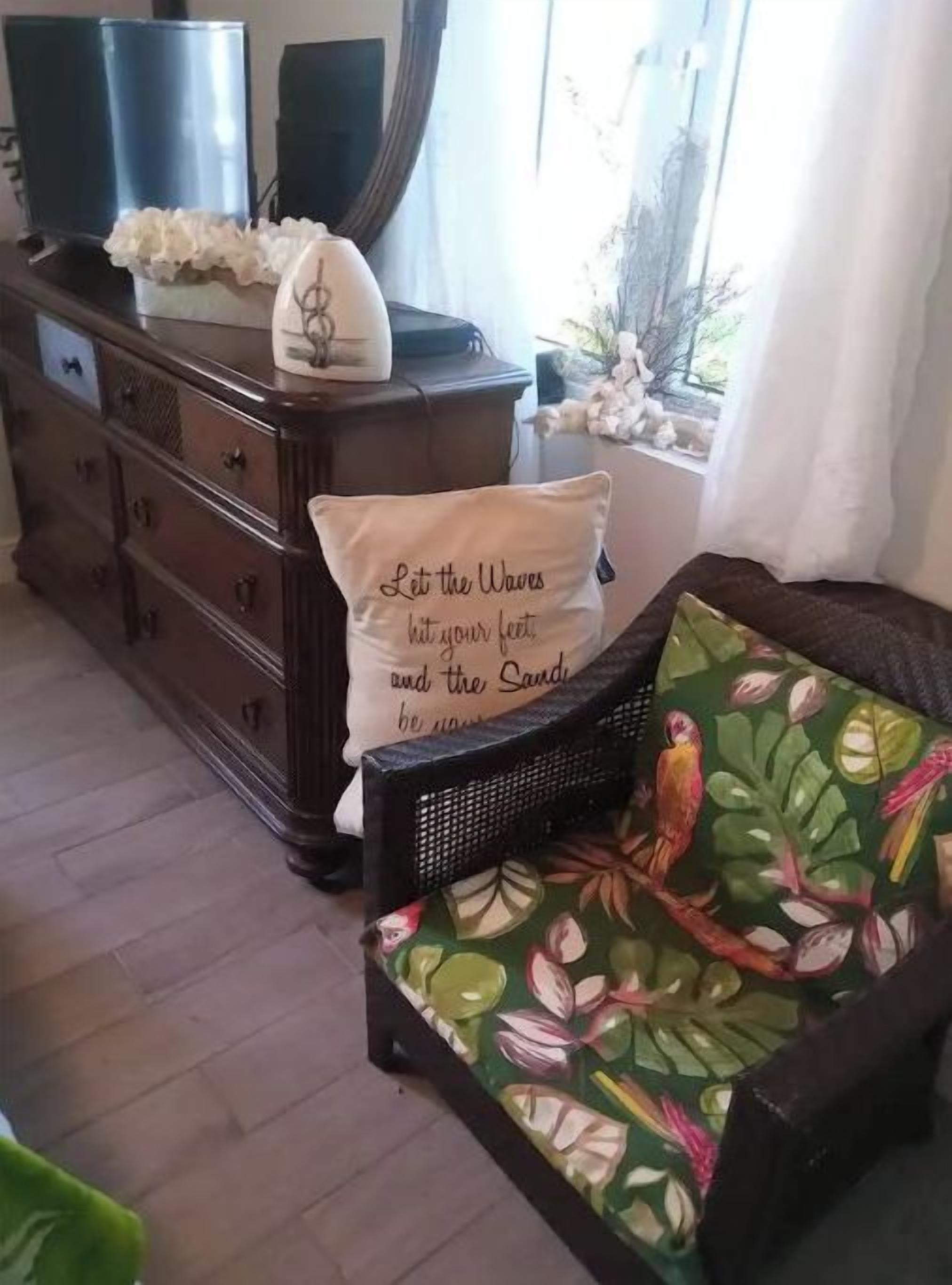 Un salon avec un canapé, un meuble en bois et un coussin décoratif.