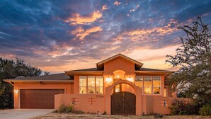 A single-story house with a garage, a large arched entrance, and a number '17704' on the wall. - Hill Country Guest Retreat Near Wedding Venues, Breweries, & Wineries (Dripping Springs)
