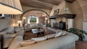 Un salón amplio con chimenea, asientos cómodos y una estantería.
