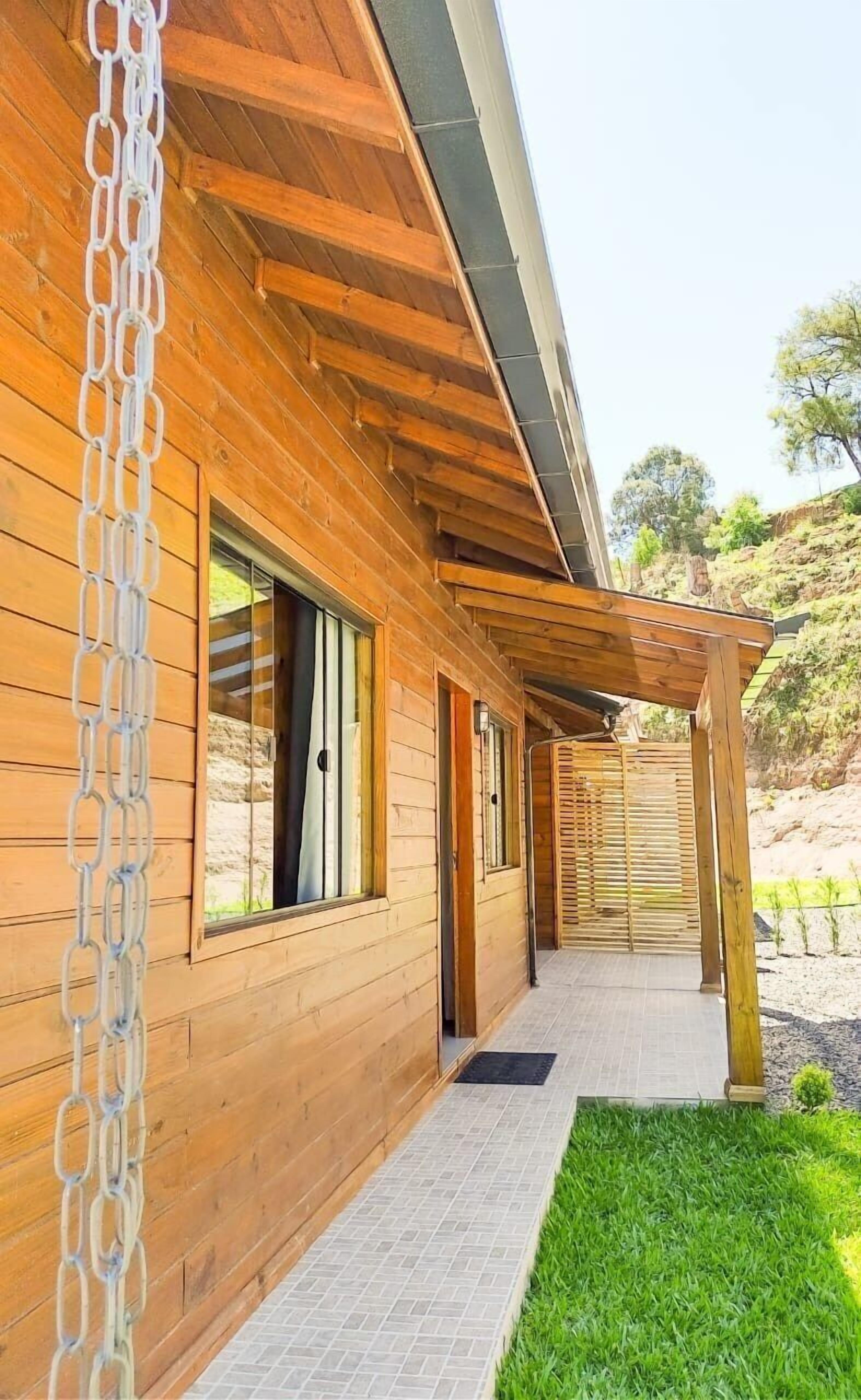 Ein Holzhaus mit einer Veranda und einem Drahtzaun.