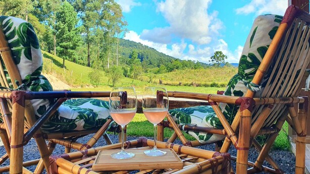 Uma poltrona de bambu com vista para uma paisagem verde exuberante.