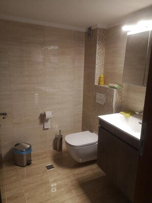 Een douche, een haardroger, handdoeken, toiletpapier