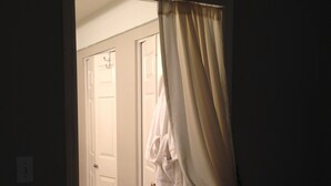 Um corredor com uma porta branca e um roupão branco pendurado na parede.