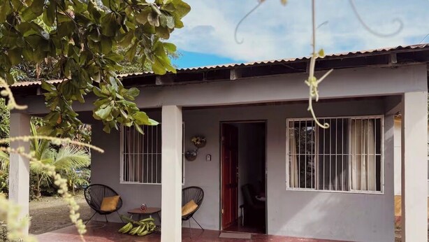 A house with a porch, two chairs, and a door. - House with excellent location in Bagaces Guanacaste (Salitral)