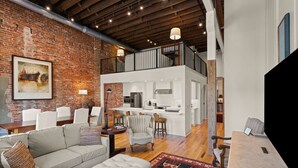 A spacious living area with a modern kitchen, a dining area, and a loft with a balcony. - The Kress Brunswick (Brunswick)