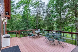 A wooden deck with outdoor furniture, surrounded by trees. - Cabin on Dale Hollow - Park your boat on shore and walk up to the cabin. (Albany)