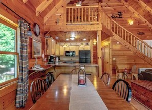 A wooden cabin interior with a dining area, kitchen, and staircase. - Cabin on Dale Hollow - Park your boat on shore and walk up to the cabin. (Albany)