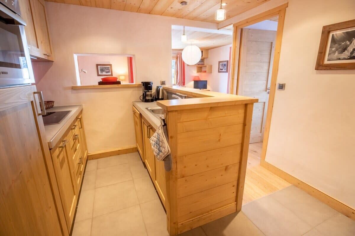 A compact kitchen with wooden cabinets, a built-in oven, and a small countertop.
