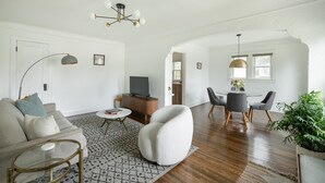 A spacious living room with a sofa, coffee table, and a dining area with chairs and a table. - Quiet and Modern Designed Cottage in St Paul (St. Paul)