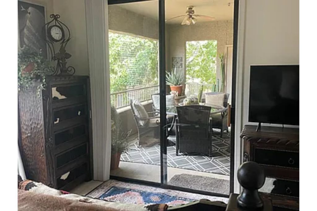 A room with a sliding glass door leading to an outdoor patio area.