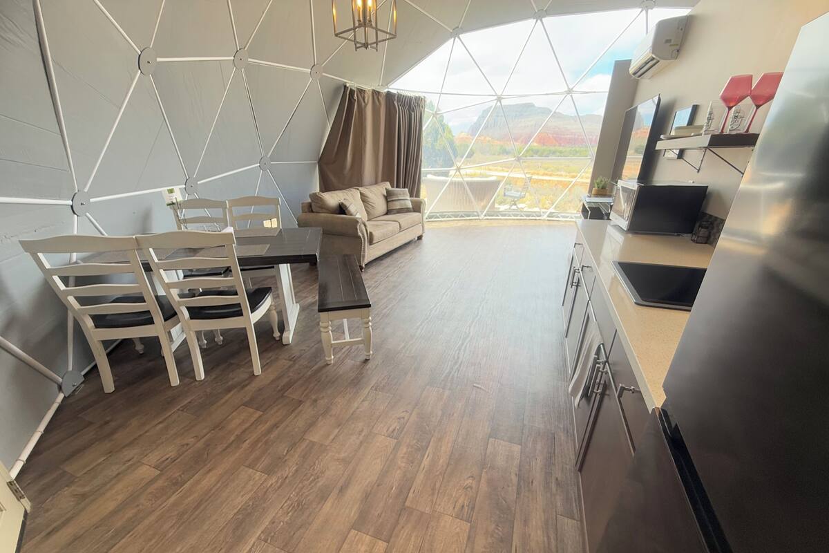 Un intérieur moderne aux lignes géométriques, comprenant un coin repas, un canapé et une cuisine.