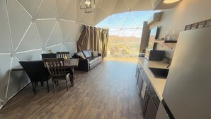 Een moderne, open woonruimte met een eethoek, bank en keuken.