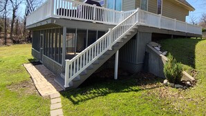 A two-story house with a covered deck and a staircase leading to the upper level. - Gorgeous lake house with sandy beachfront. Welcome to Lost  World Landing  (Eufaula)