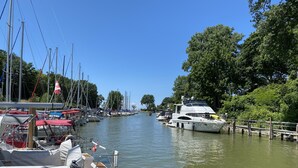 A marina with boats docked along a calm waterway, surrounded by lush greenery and a clear blue sky. - Cozy Sandy Pines Cottage Suite, right on Lake Huron in a Carolinian Forest,  (Grand Bend)