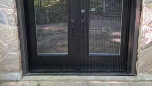 A black double door with a keypad lock, set in a stone wall. - Cozy Sandy Pines Cottage Suite, right on Lake Huron in a Carolinian Forest,  (Grand Bend)
