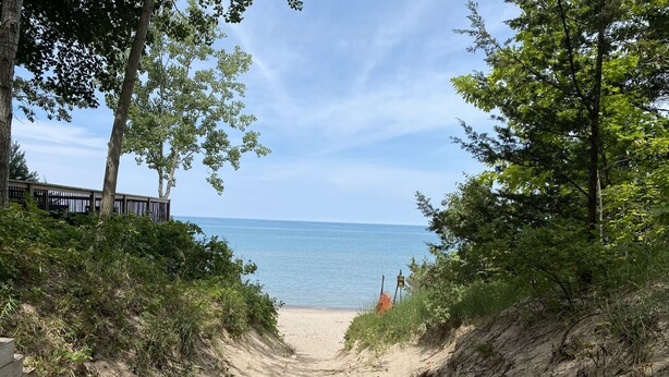 A sandy path leading to a beach with a wooden fence on one side and trees on the other. - Cozy Sandy Pines Cottage Suite, right on Lake Huron in a Carolinian Forest,  (Grand Bend)