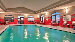 A swimming pool with clear water, surrounded by red-tiled walls and large windows. - 1 Bedroom | Fully Equipped Suite + Wi-Fi! (Cheyenne)