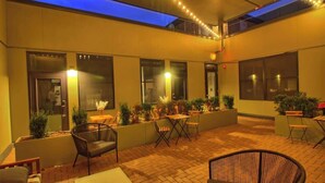 An outdoor patio area with seating, planters, and a blue-lit ceiling. - Chic Ultramodern Studio Loft w/ Designer Features (Saint Louis)