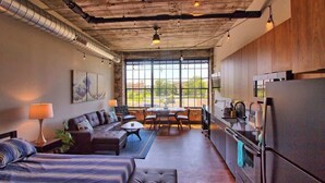 A modern interior with a sofa, a dining table, and a kitchen area. - Chic Ultramodern Studio Loft w/ Designer Features (Saint Louis)