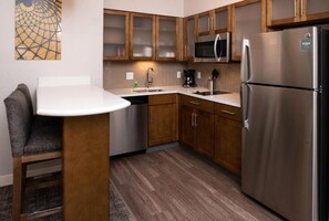 Efficient kitchen with microwave, stainless steel appliances, and a small island.