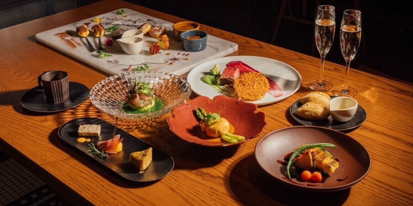 A dining table with various dishes and drinks.