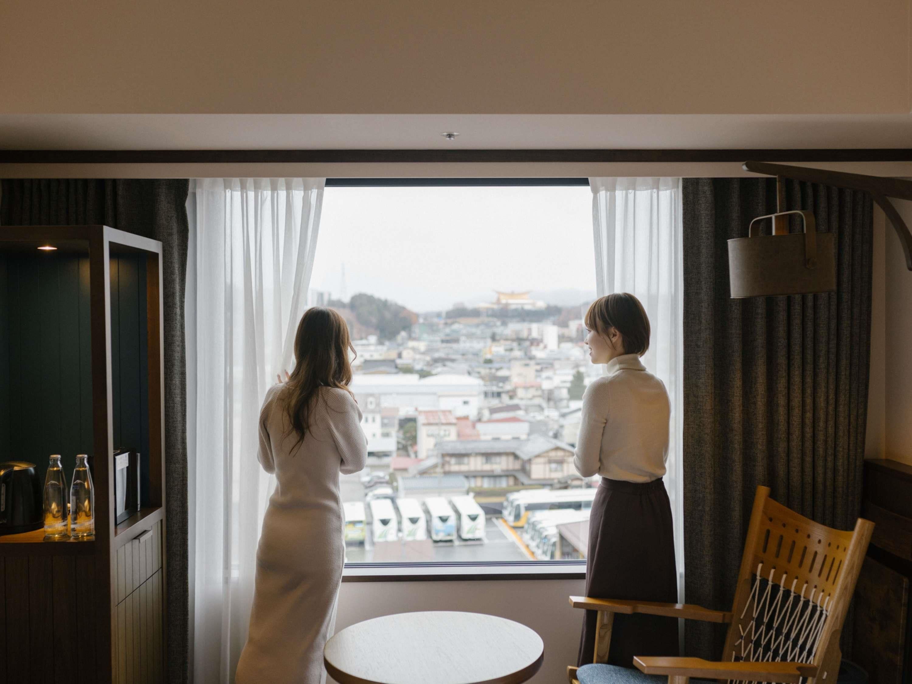 A room with a large window, a round table, and a chair.