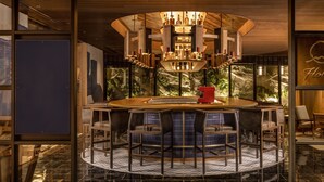 A modern bar area with a circular seating arrangement, a central bar counter, and a view of a mountainous landscape through large windows. - Mercure Hida Takayama (Takayama)