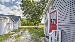 A gravel path leading to a building with a red door and a white porch. - Pet-Friendly & Peaceful Northern Michigan Gem (Newberry)