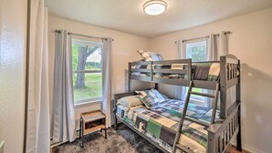 A bunk bed room with a window, a small table, and a ceiling light. - Pet-Friendly & Peaceful Northern Michigan Gem (Newberry)