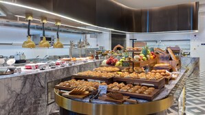 Un bufé con diversos productos horneados y frutas.