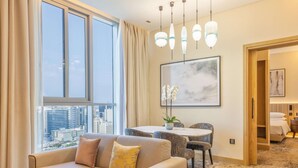 A modern hotel room with a large window, a dining area, and a bed. - Embassy Suites by Hilton Doha Old Town (Doha)