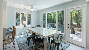 A dining area with a glass-top table, dark chairs, and a blue rug. - PET FRIENDLY Fairway Oaks Villa! Kiawah West Beach (Kiawah Island)