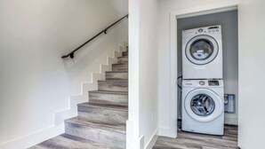 A staircase leading to a laundry area with two stacked washing machines.