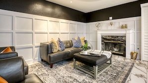 A modern living room with a sectional sofa, a coffee table, and a fireplace.