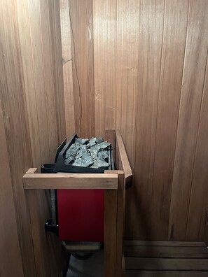 Een houten bank met een rode zitting en een metalen frame.