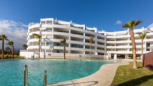 A modern hotel with a pool, palm trees, and a clear blue sky. - Ref. 396309 (Motril)