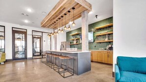 Una cocina moderna con una isla central, taburetes de bar e iluminación colgante.