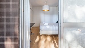 Ein modernes Hotelzimmer mit Bett, Schreibtisch und einer Pendelleuchte.