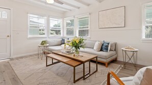 A spacious living room with a wooden coffee table, a sofa, and a small side table.