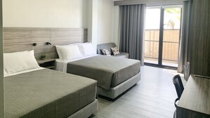 Une chambre d’hôtel avec deux lits, un bureau et une vue sur l’extérieur.