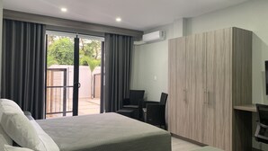 Une chambre d’hôtel avec deux lits, un bureau et une armoire.