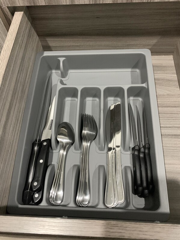 A drawer with compartments containing various kitchen utensils including knives, spoons, and forks. - Whitestone Parkview Tamarindo 2 queen bed studio w/kitchen 7 min walk to beach (Tamarindo)