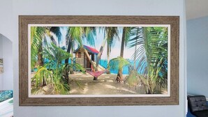 A framed picture of a beach scene with a hammock, palm trees, and a small hut. - Beach like you've never seen! Heated pool/spa! (Port St. Lucie)