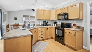 Una cocina moderna con armarios de madera, una isla central, un microondas y una estufa.