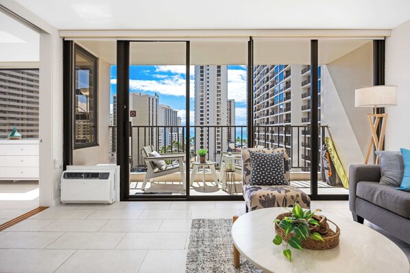A modern living room with a balcony, a sofa, a coffee table, and a dining area.