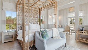 Una habitación amplia con una cama grande, un sofá, una zona de comedor y vistas al exterior.