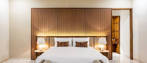 A hotel room with a large bed, two bedside tables with lamps, a wooden headboard, and a marble floor.