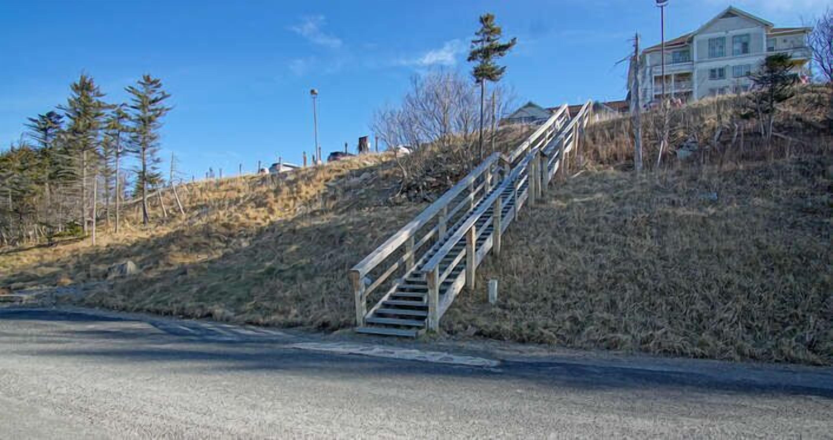 Un escalier menant vers le haut, avec un bâtiment en arrière-plan.