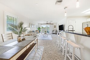 Relax in this inviting living area with a dining table, potted plant, and large window.