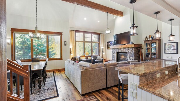 A spacious living area with a stone fireplace, a large sofa, and a dining table.